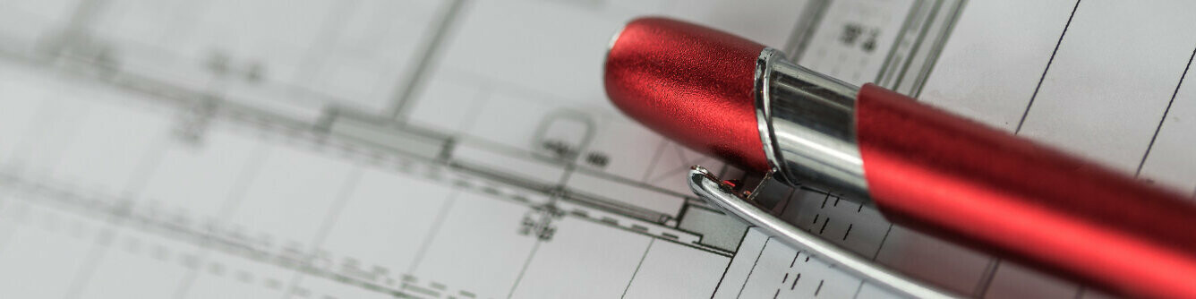 Červené PREFA pero leží na pláne