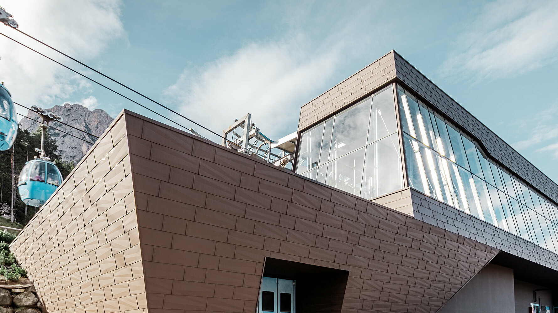Údolná stanica lanovky v Južnom Tirolsku s moderným obložením strechy a fasády od spoločnosti PREFA vo farbe hnedá.
