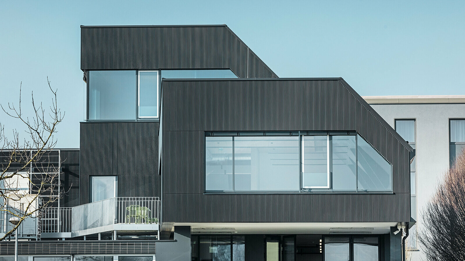 Bočný pohľad na budovu kaviarne Amann v slnečný deň. Na ochranu budovy bol použitý prelamovaný profil vo farbe čierna.