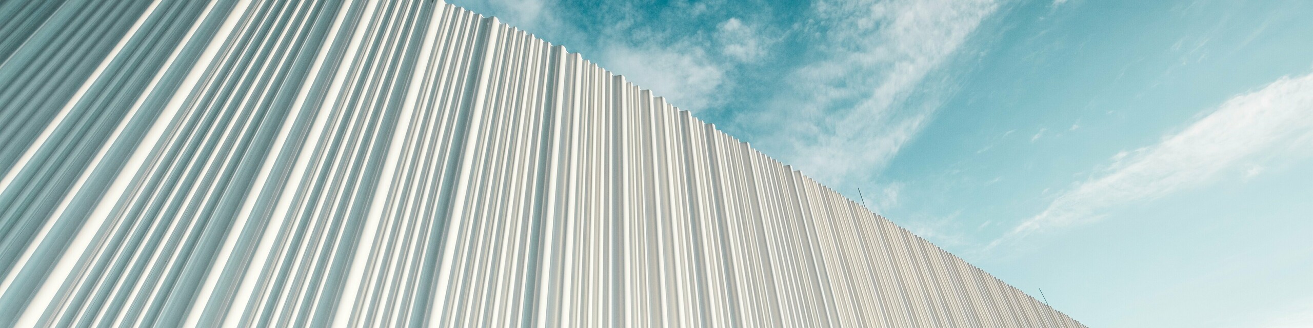 Úchvatná architektúra s bielou hliníkovou fasádou PREFA vo Walter Business Parku pri Viedni. Fasáda z profilov vyrobených na mieru vytvára vďaka svojmu plynulému vlnitému charakteru fascinujúcu hru svetla a tieňa. Tri rôzne tvary profilov zaisťujú mimoriadny efekt hĺbky a dodávajú budove štýlovo čistý a zároveň dynamický vzhľad. Trvanlivý, odolný voči poveternostným vplyvom povrch PREFA kombinuje modernú estetiku s funkčnou dokonalosťou – skutočný vrchol súčasného dizajnu fasád, ktorý zviditeľňuje architektonickú kvalitu a technickú prepracovanosť.