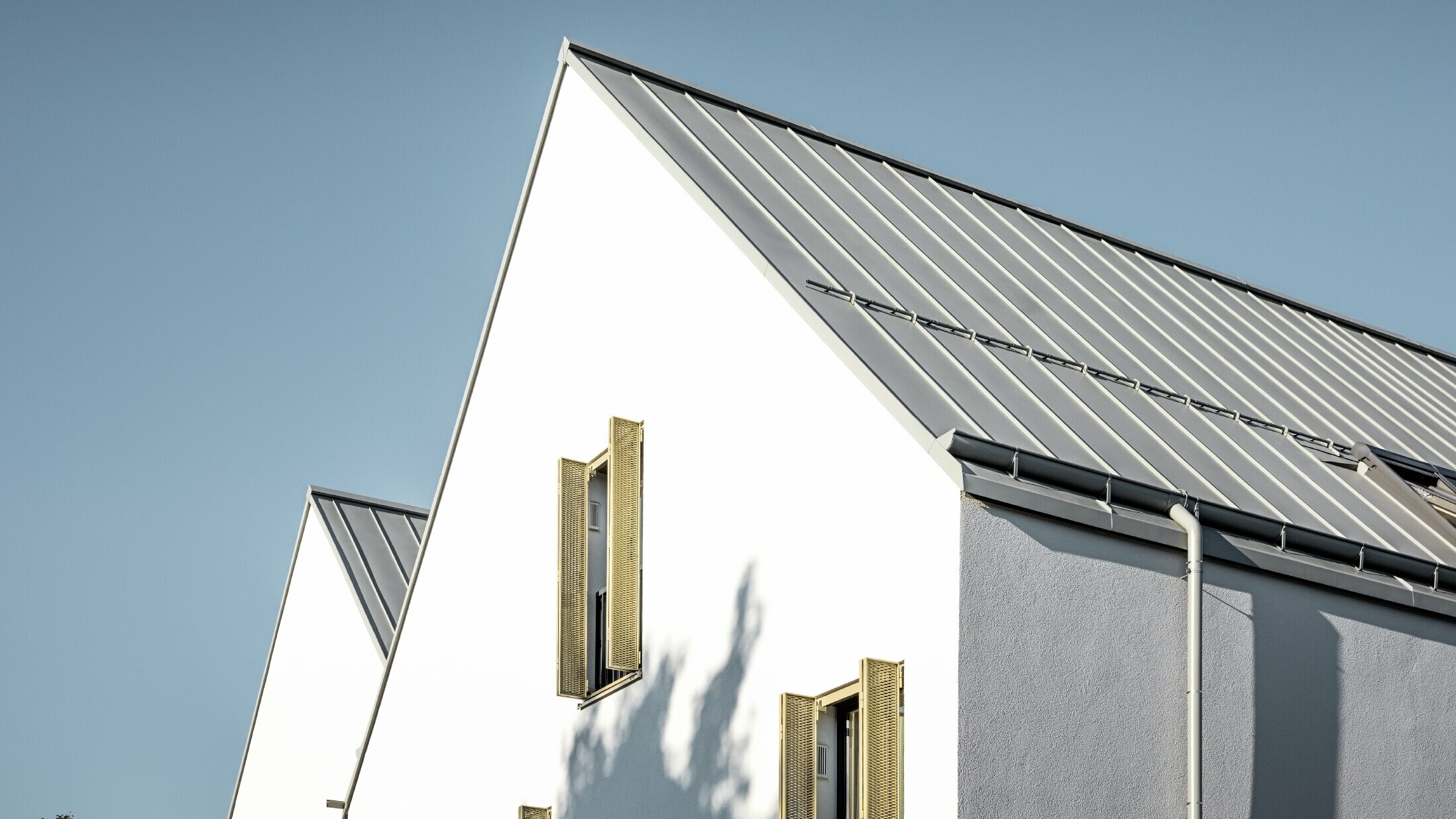 Sedlová strecha bez previsnutej strechy, zakrytá s PREFALZ vo farebnom vyhotovení P.10 zinkovošedá s PREFA nástrešným žľabom