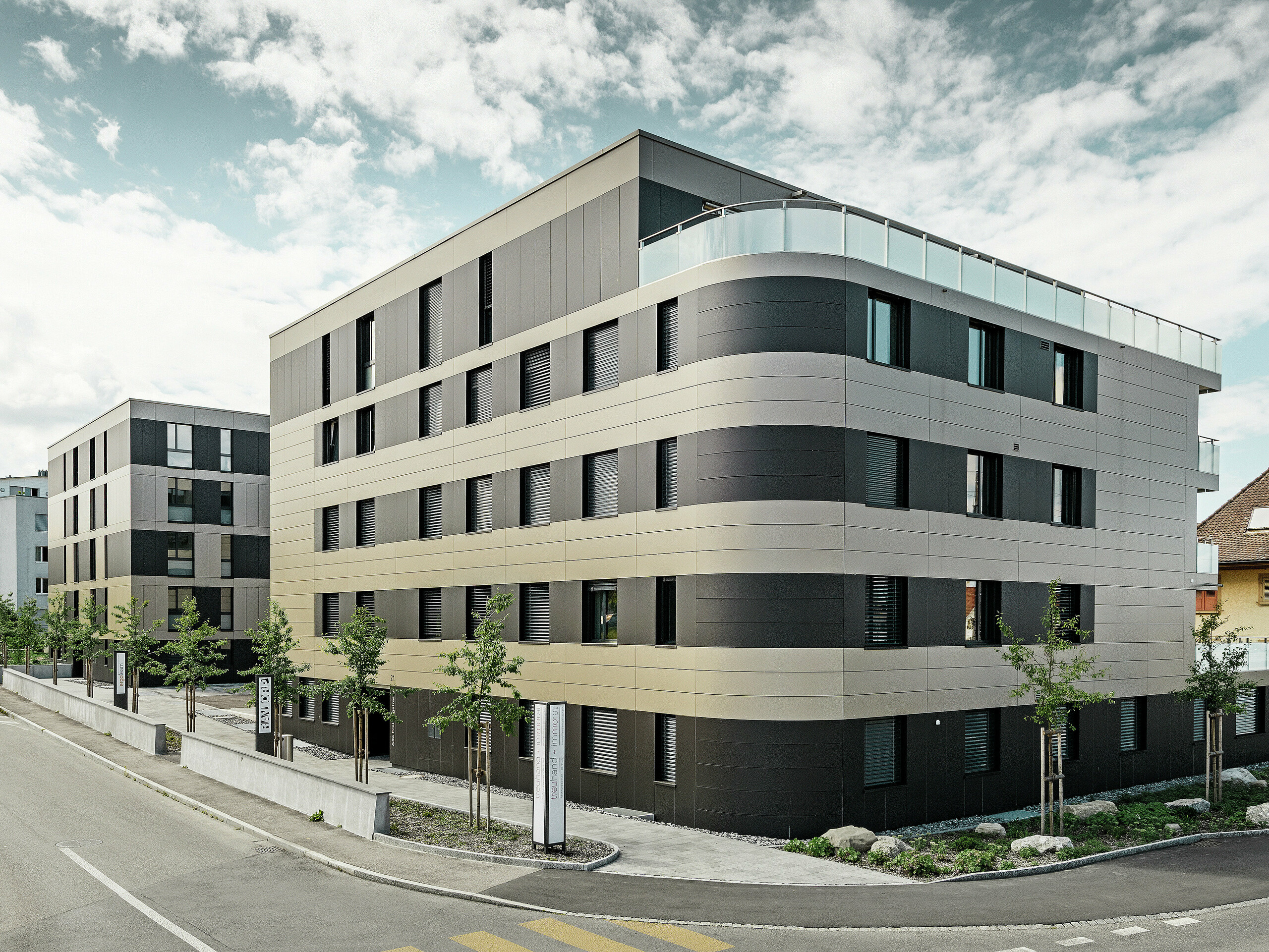 Bytový dom s hliníkovou fasádou bronzovej farby s čiernošedými prvkami