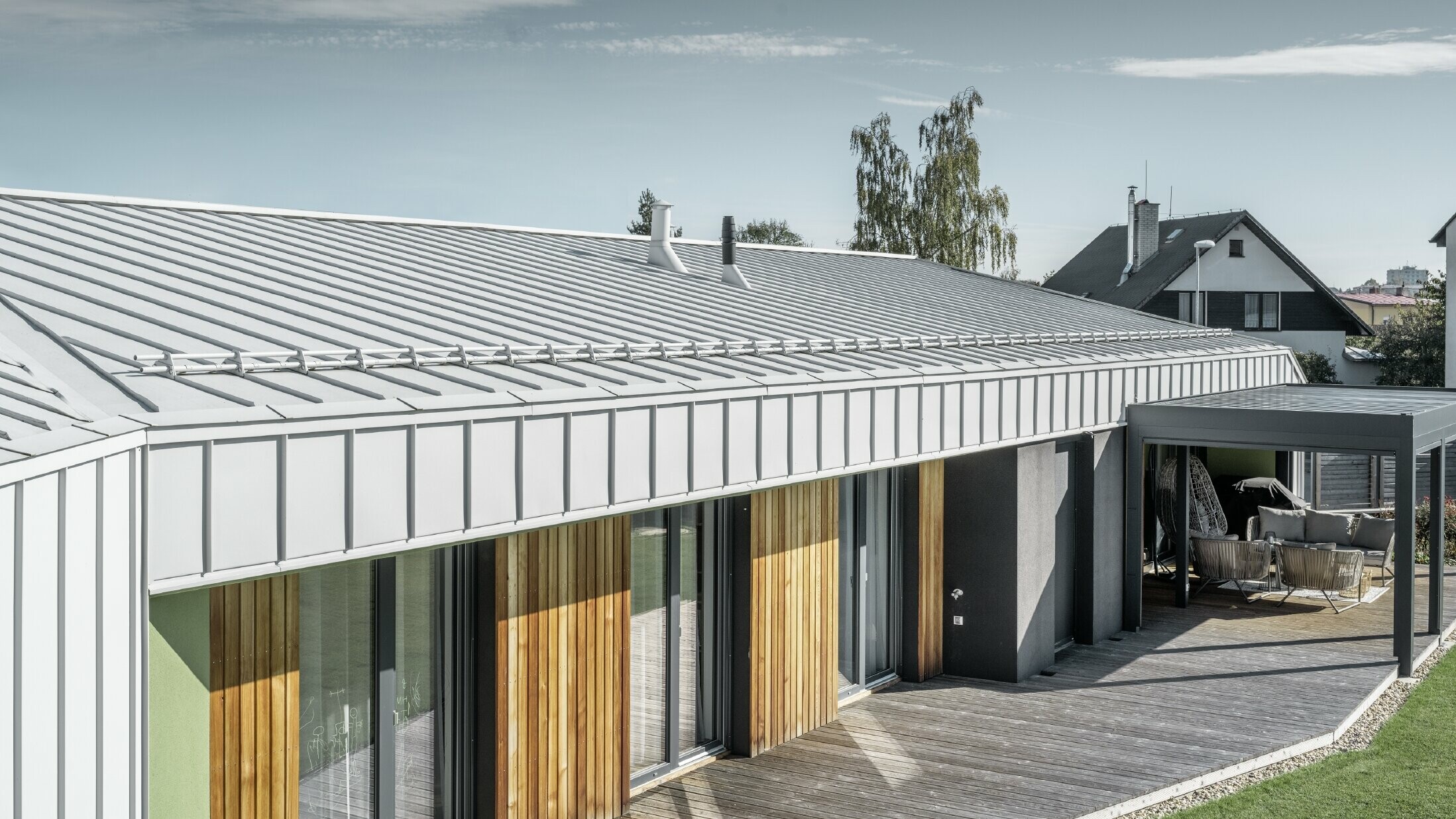 Bungalov so strechou PREFALZ a fasádou vo farebnom vyhotovení prefa biela a drevenou terasou