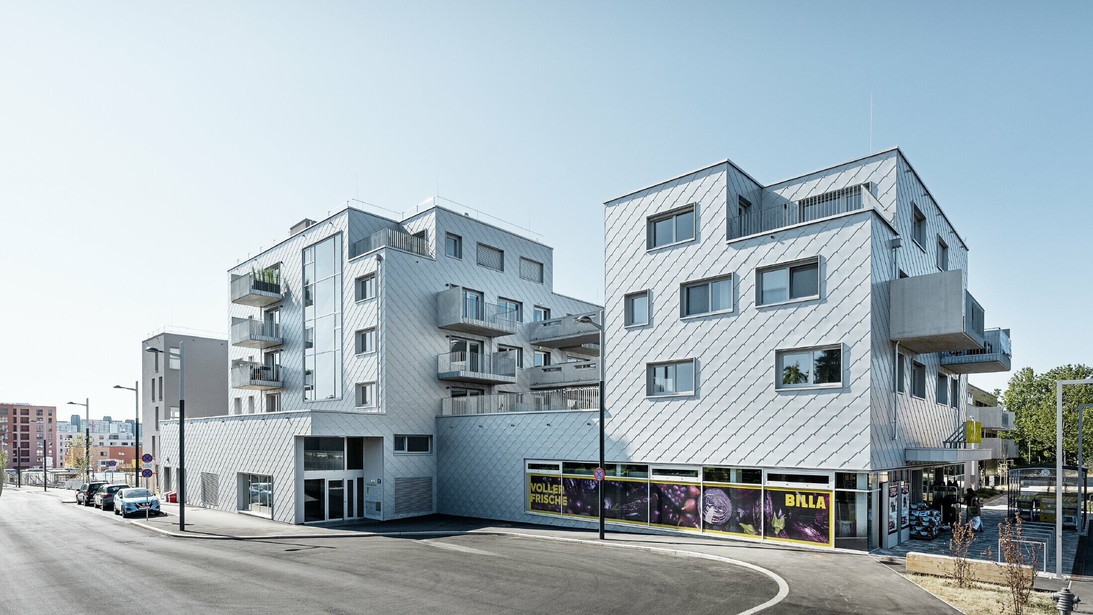 Bytové domy s plochou strechou a fasádnym obložením s PREFA fasádnou šablónou 44 × 44 vo farbe strieborná metalíza