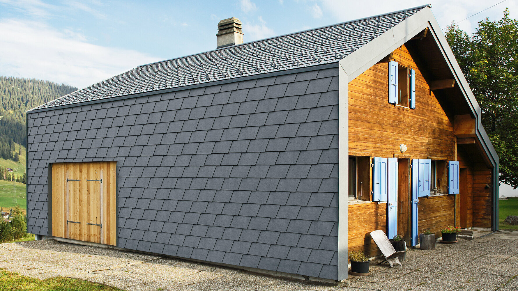 Moderný rodinný dom obložený fasádnym šindľom PREFA v antracitovej farbe a drevenými prvkami.