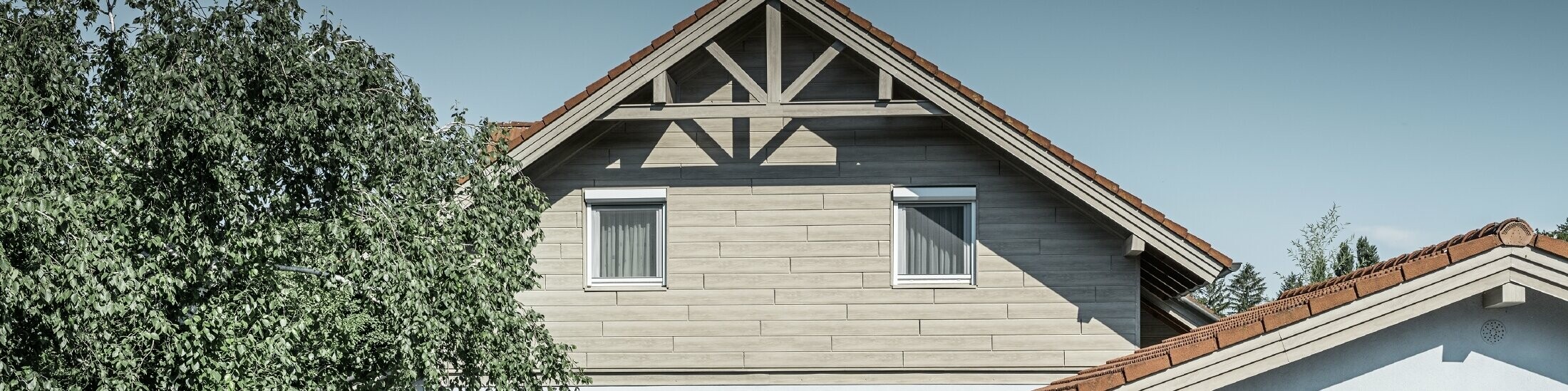 Hliníková fasáda s dreveným vzhľadom od spoločnosti PREFA tu bola položená vodorovne a vôbec ju netreba prelakovať.