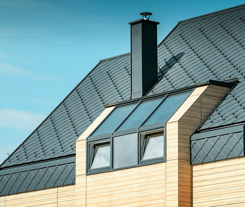 Rodinný dom s hliníkovou sedlovou strechou antracitovej farby bez previsu a s fasádou v drevenom vzhľade